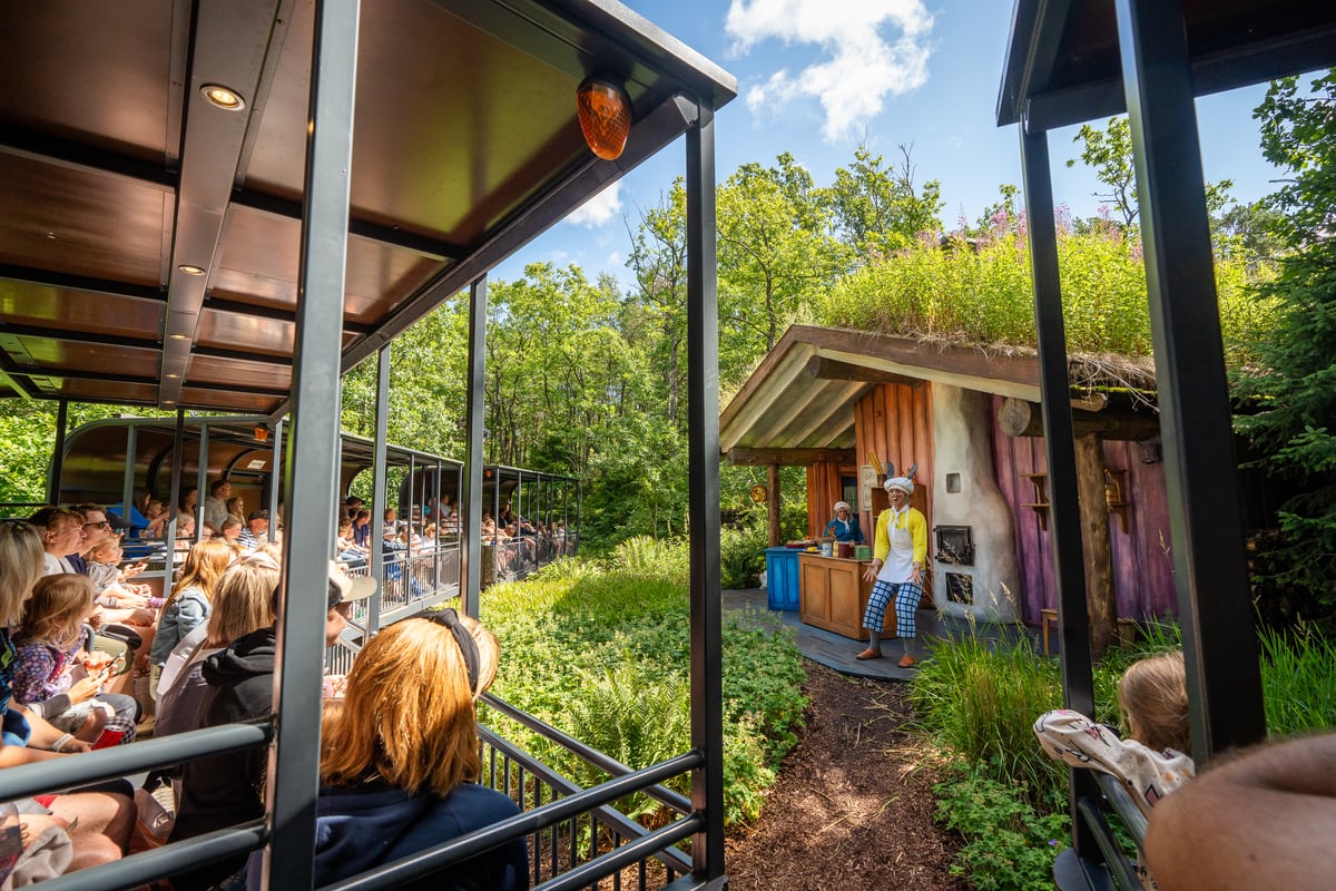 Gjester sitter i toget og følger nøye med på underholdningen Reisen gjennom Hakkebakkeskogen.